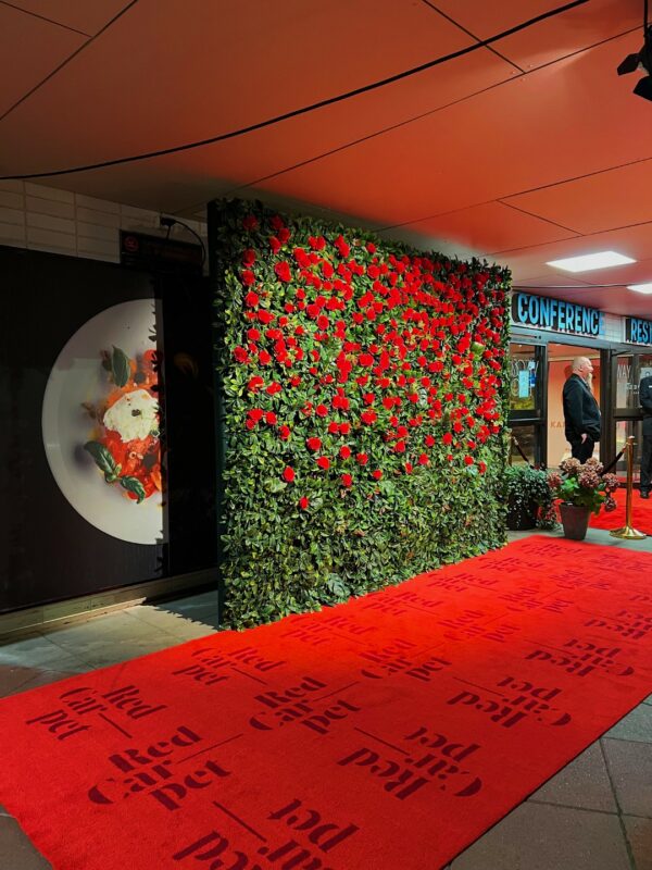 Red Carpet festareille silkkikasveista rakennettu ruususeinä.